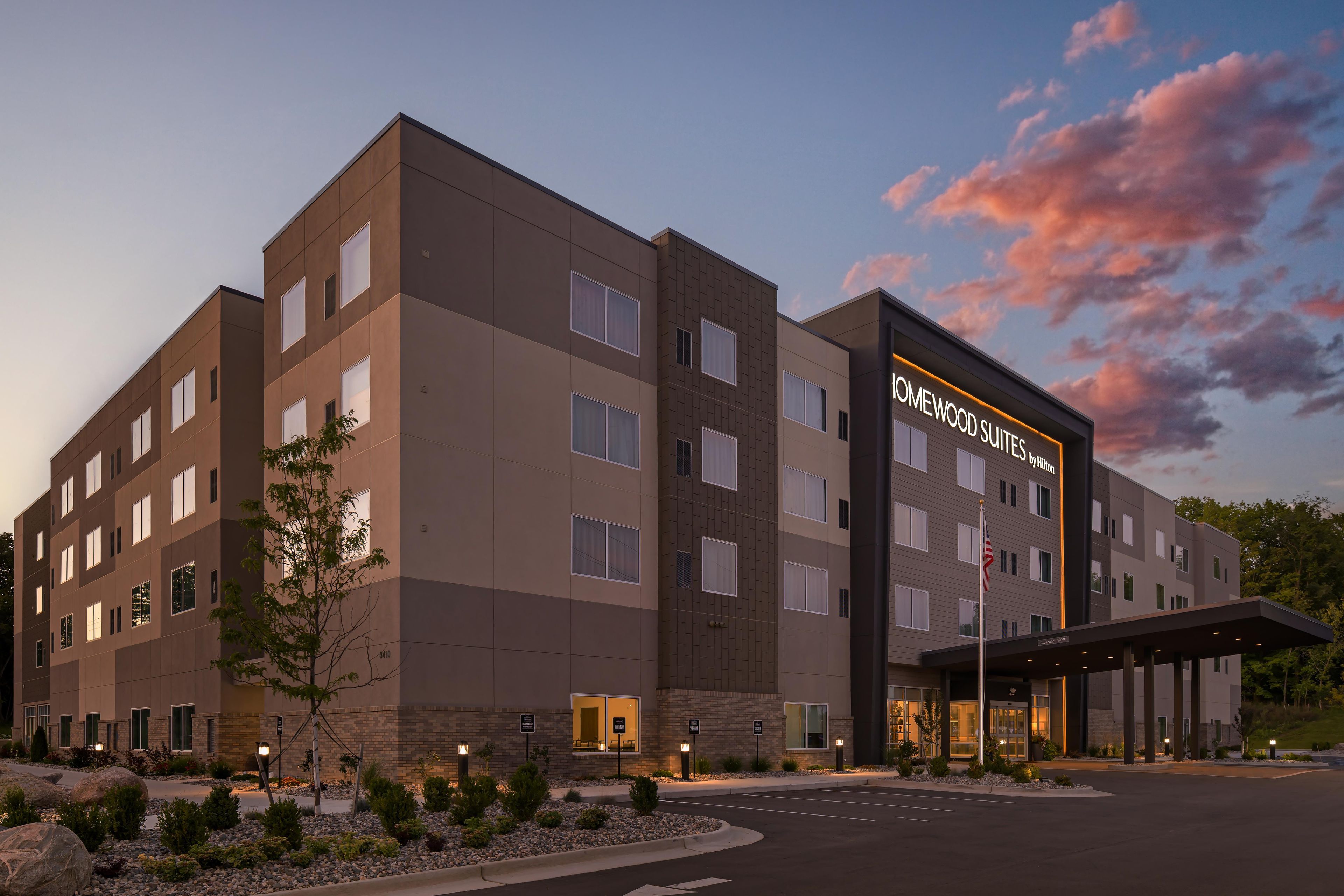 Un bâtiment d’hôtel avec une enseigne indiquant « Homewood Suites by Hilton » et une entrée abritée.
