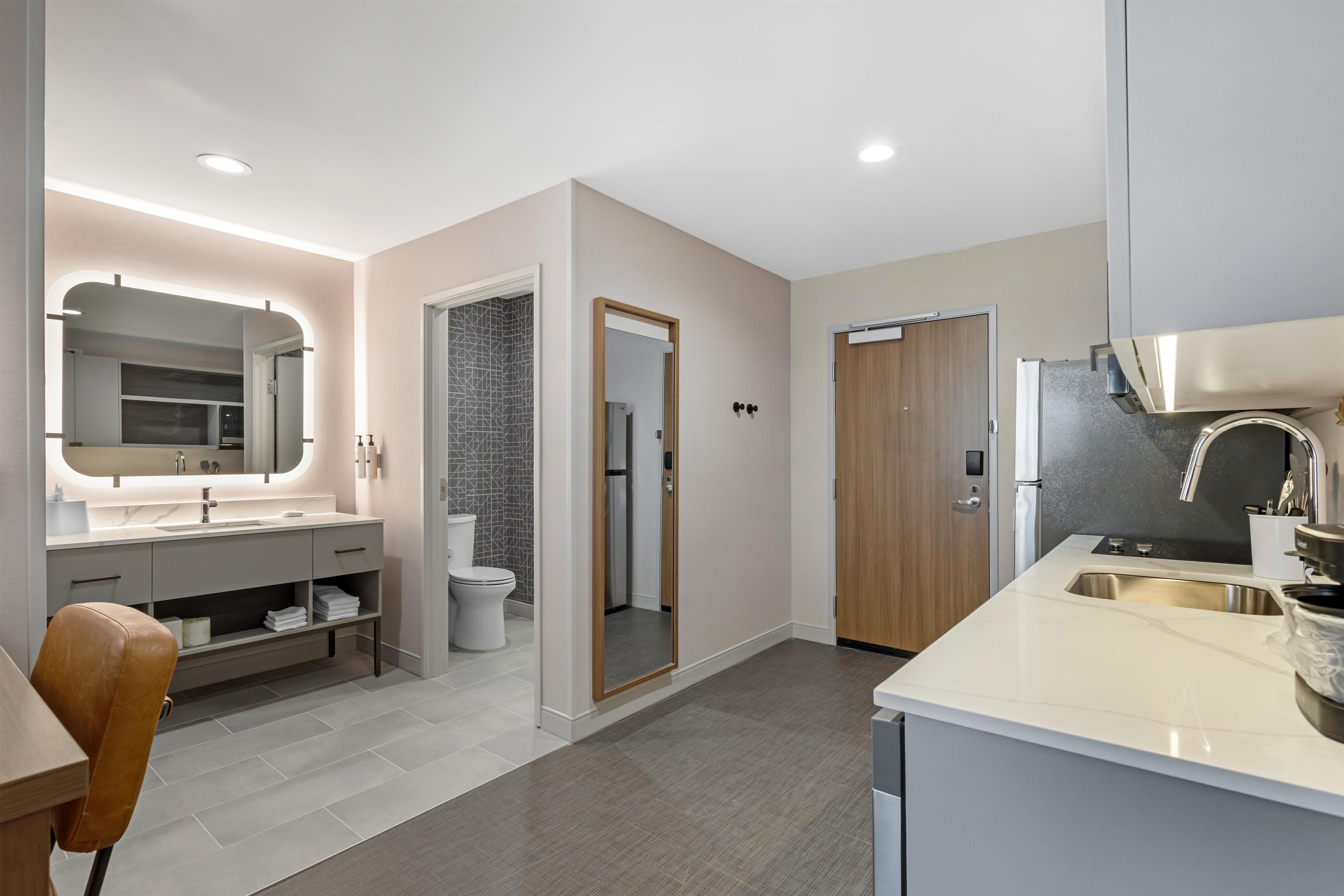 Une salle de bain moderne comprenant un meuble-lavabo, des toilettes et un espace douche.