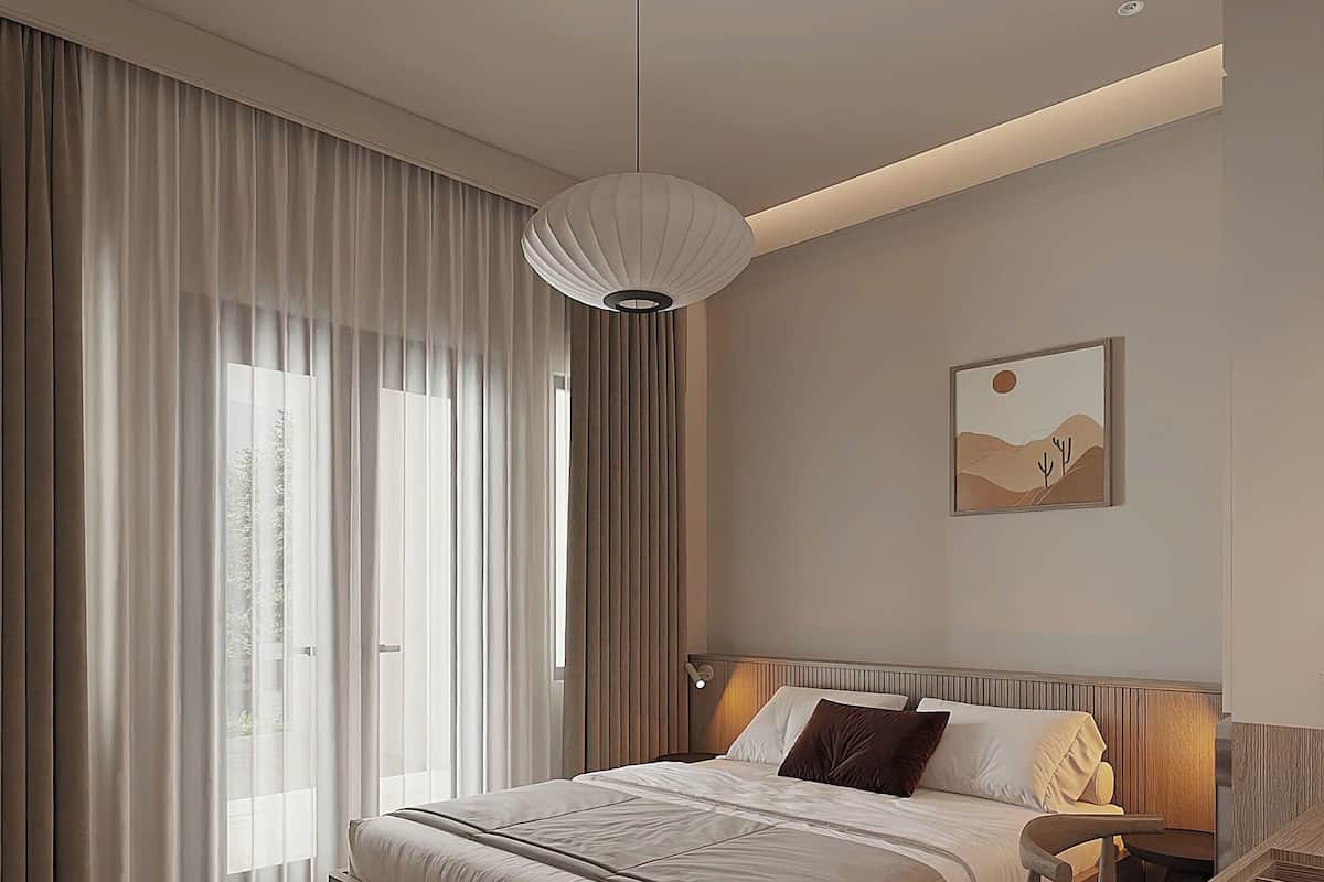 A modern bedroom with a large bed, a desk, and a hanging light fixture.
