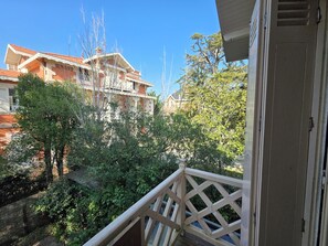 Ein Balkon mit Blick auf ein Gebäude und Bäume.