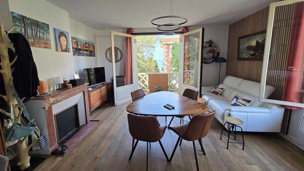 Un salon comprenant une table à manger, un canapé et une cheminée.
