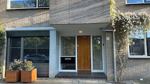 Un bâtiment à deux étages, doté d’un porche carrelé, d’une porte en bois et d’une enseigne portant le numéro « 11 ».