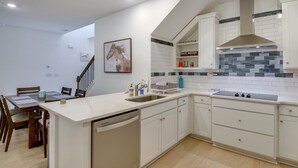 A modern kitchen with white cabinetry, a dishwasher, a sink, and a stove. - Beach, Eats, Shops! Sunny Stay in our New 3BR Townhome in Peaceful Palm Coast FL (Palm Coast)