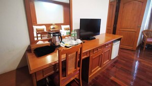 A wooden desk with a television, a kettle, and a chair. - Lanna Oriental Maejo (San Sai)