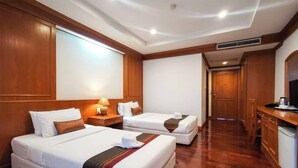 A hotel room with two beds, a desk, a chair, a TV, and a wardrobe. - Lanna Oriental Maejo (San Sai)