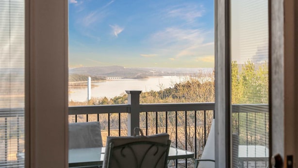 Uma varanda com vista para um rio e montanhas ao longe.