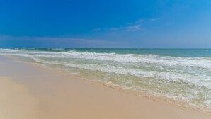 Une plage avec un ciel dégagé et des vagues.