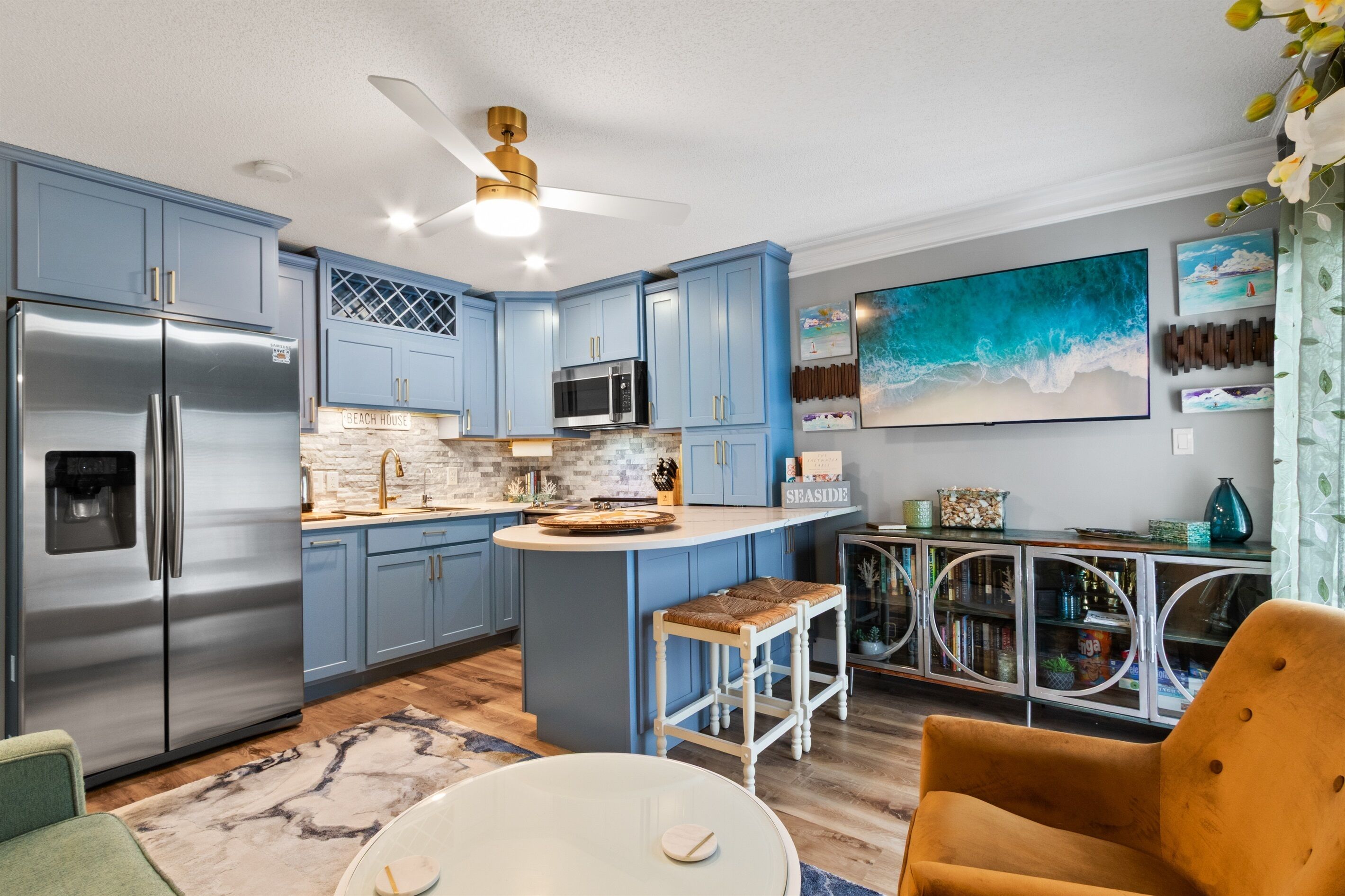 A modern kitchen with blue cabinets, stainless steel appliances, and a central island.