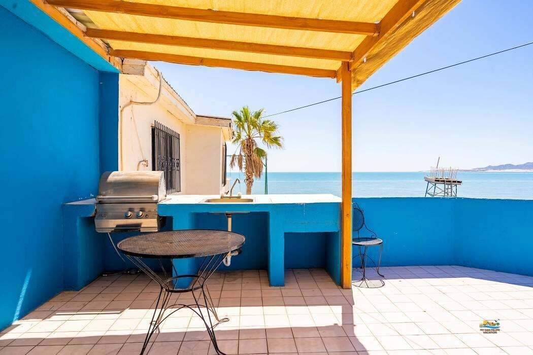 Upstairs patio features a charcoal barbecue grill, perfect for preparing gourmet meals outdoors while staying just steps from the beach
