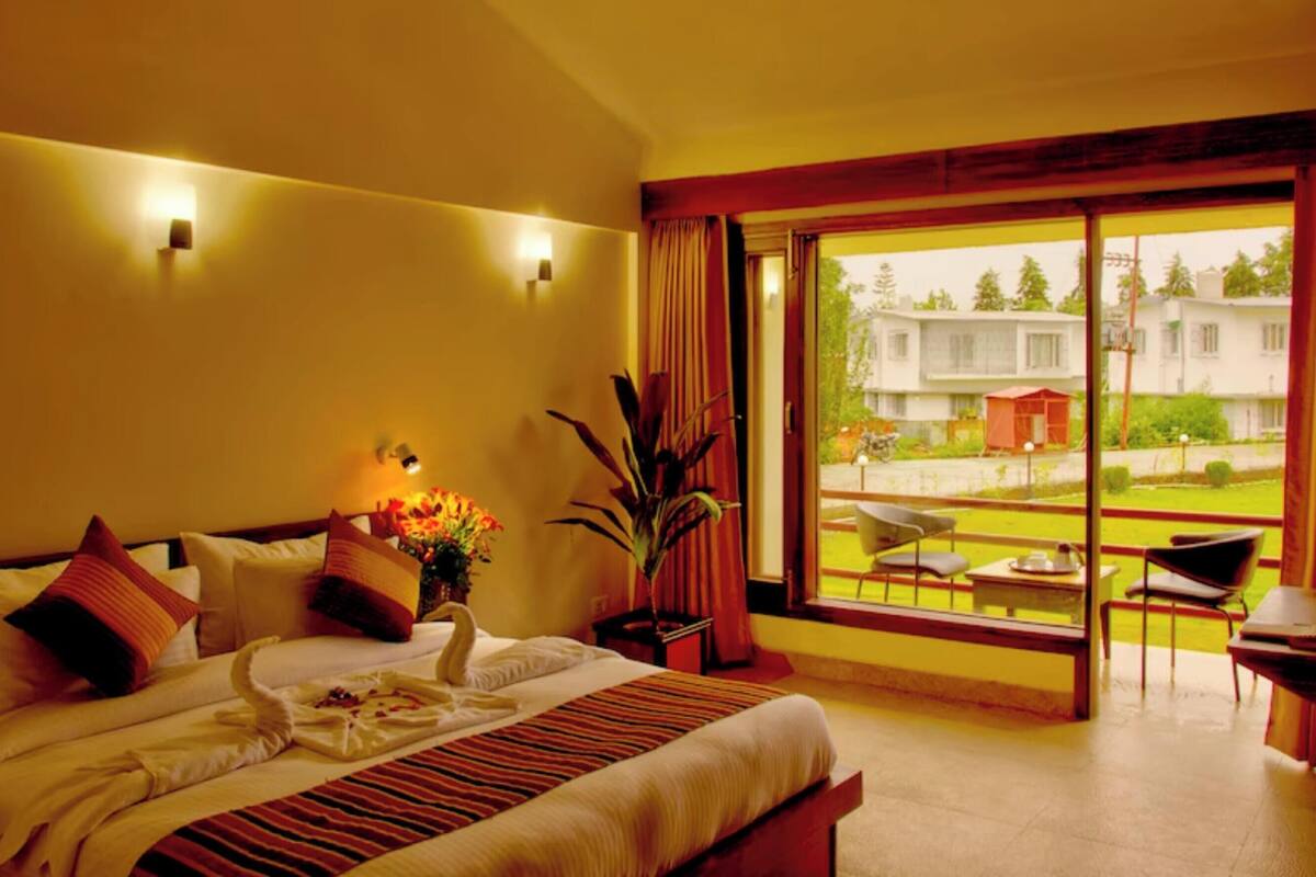 Une chambre d’hôtel avec un lit, une fenêtre donnant sur l’extérieur et une table avec des chaises.