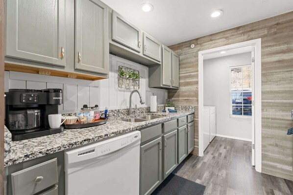 A kitchen with a coffee maker, sink, and cabinets. - Branson Heights Retreat (Branson)