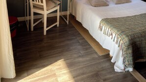 A bedroom with a bed, a desk, a chair, a window with blinds, a hanging lamp, and a small plant. - Bedroom and bathroom (Gragnague)