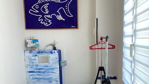 A bathroom with a toilet, a sink, a blue-framed mirror, a blue stool, a tripod, and a framed artwork on the wall. - Bedroom and bathroom (Gragnague)