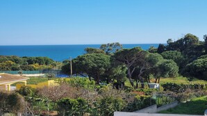 A coastal residential area with houses, trees, and a view of the sea. - Vila Rosal standing Ocean view, 300m near to the magnificent Praia São Rafael (Albufeira)
