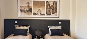 A hotel room with a bed, two pillows, a nightstand, a lamp, and a framed picture above the bed. - Vila Rosal standing Ocean view, 300m near to the magnificent Praia São Rafael (Albufeira)