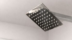 Un baño moderno con ducha de hidromasaje cuadrada y barra horizontal.