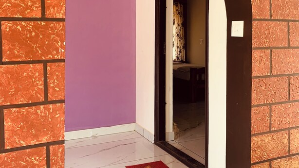 Un arco de entrada a un cuarto con pared morada y piso de baldosas.