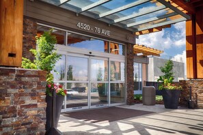 A building entrance with a glass door, stone facade, and a sign reading '4520 - 76 AVE'. - Edmonton Hotel & Convention Center (Edmonton)