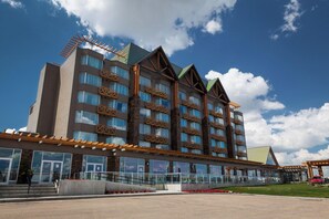 A multi-story hotel with a modern architectural design, featuring balconies, large windows, and a covered entrance area. - Edmonton Hotel & Convention Center (Edmonton)