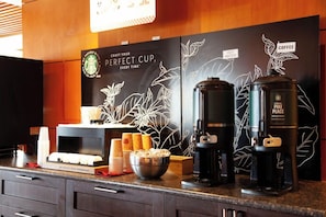 A coffee station with a coffee maker, a pike place medium roast coffee container, and a Starbucks cup holder with disposable cups. - Edmonton Hotel & Convention Center (Edmonton)