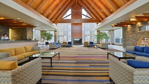 A spacious lobby with high ceilings, stone walls, and a variety of seating arrangements. - Edmonton Hotel & Convention Center (Edmonton)