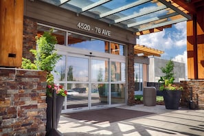 A building entrance with a glass door, stone facade, and a sign reading '4520 - 76 AVE'. - Edmonton Hotel & Convention Center (Edmonton)