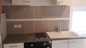 Eine Küche mit weißen Schränken, einem eingebauten Backofen und einem Spülbecken.