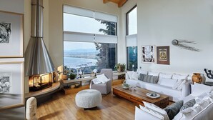 A spacious living room with a large fireplace, a sofa set, and a view of the city. - Villa Vollard  | 5 Bedrooms with Private Pool Jacuzzi and Panoramic Sea View (Heraklion)