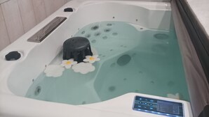  poreallas, jossa on ohjauspaneeli, kuplatoiminto ja koristeellisia kukkia.