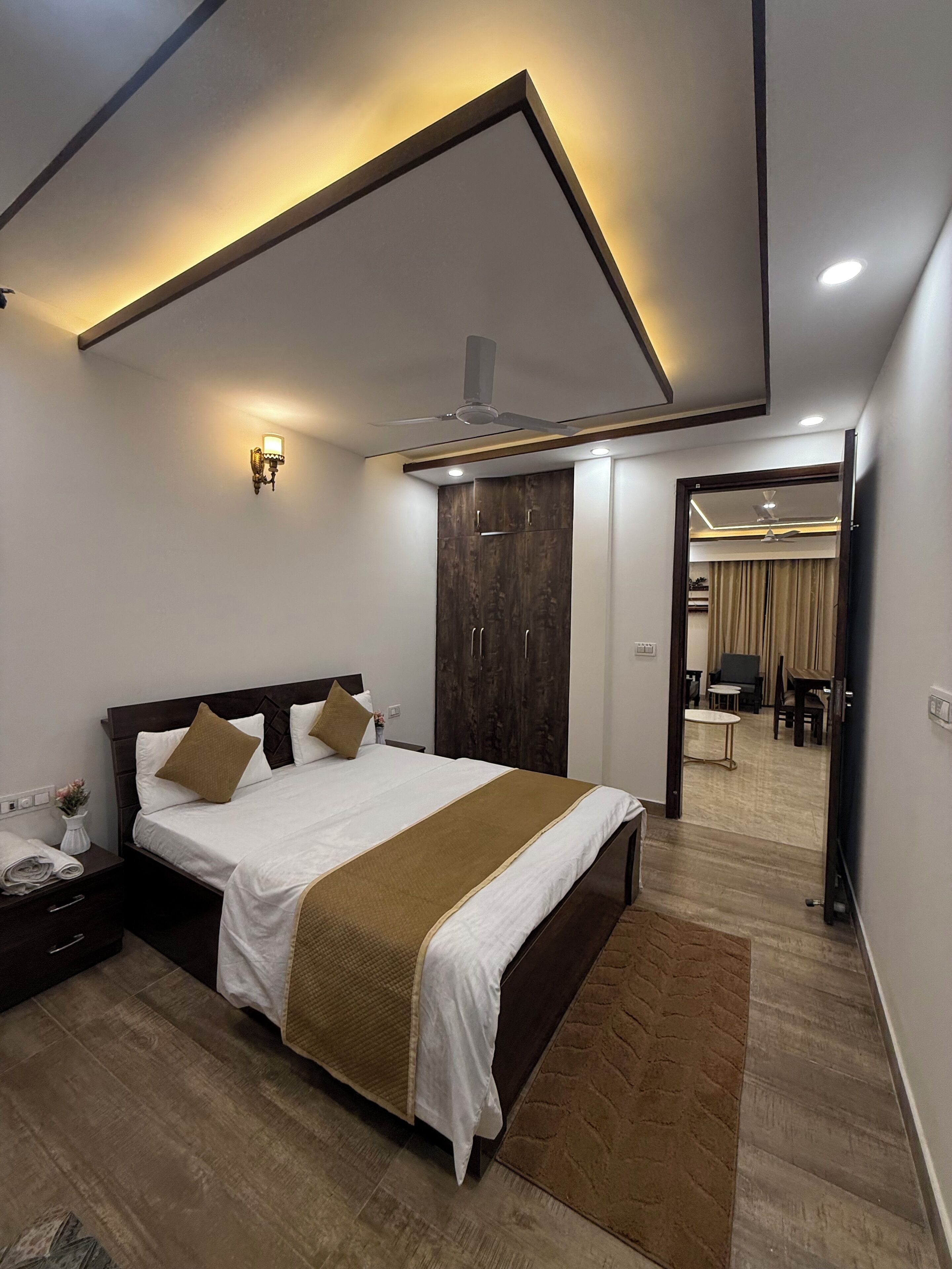 Une chambre à coucher moderne avec un lit, une table de chevet et un ventilateur de plafond.