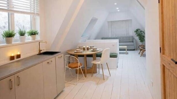 Een moderne loftkamer met een keuken, eethoek en slaapgedeelte.