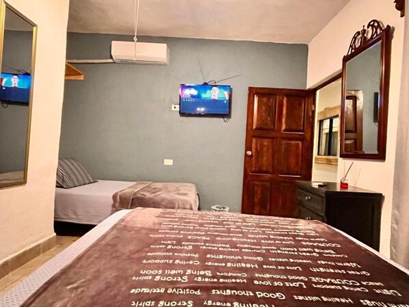 A bedroom with a bed, a television, a wardrobe, and a mirror. - Hotel 305 (Parras de la Fuente)