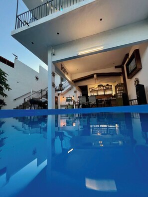 Un edificio residencial con piscina, balcón y zona de bar.