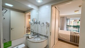Ein Badezimmer mit Waschbecken, Spiegel und Fön.