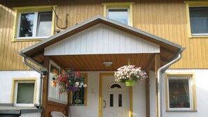 A house with a porch, a white door, and a window.