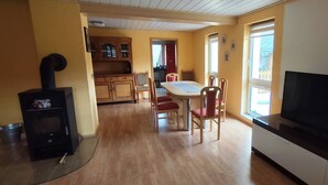 A kitchen with a dining table, chairs, a TV, and a fireplace.