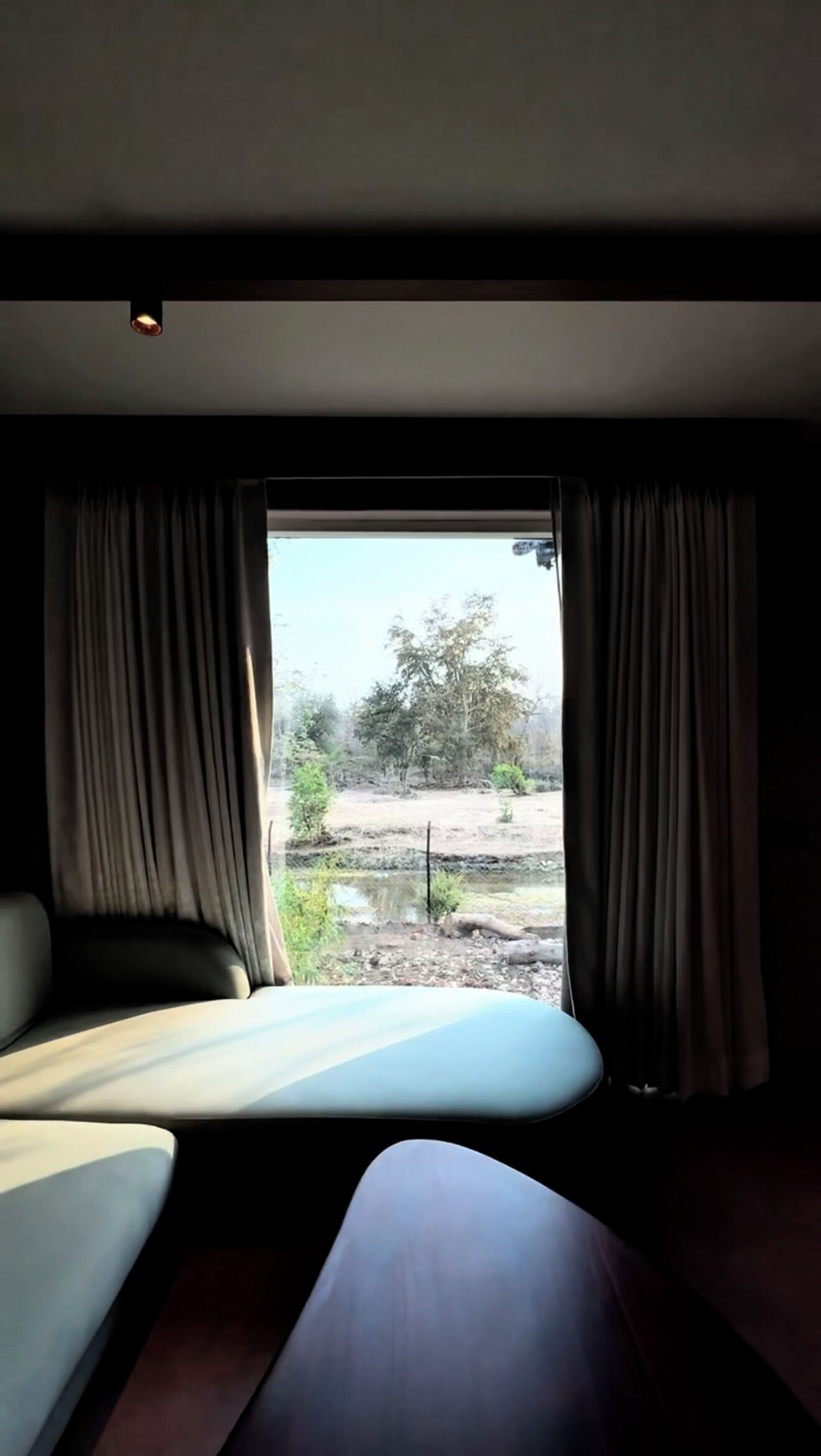 A room with a bed, a small table, and a window with curtains.