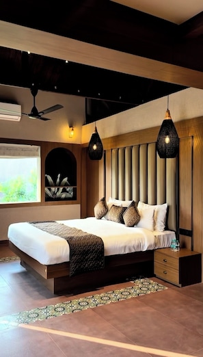 Ein modernes Schlafzimmer mit einem großen Bett, Deckenventilator, Pendelleuchten, einem Fenster mit Blick und einer dekorativen Wandverkleidung.