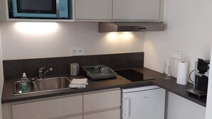 Una cucina compatta con microonde, lavello e lavastoviglie.