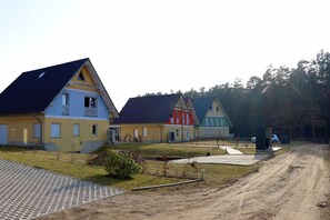 A row of colorful houses with a dirt road in front. - Seeluft vacation home with lake view in Warin for a relaxing vacation (Warin)