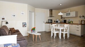 Eine moderne Wohnung mit Wohnzimmer, Essbereich und Küche.