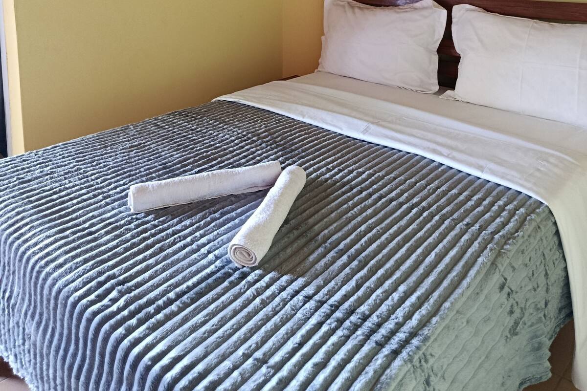 Una habitación de hotel con una cama, un cuadro en la pared y una ventana.