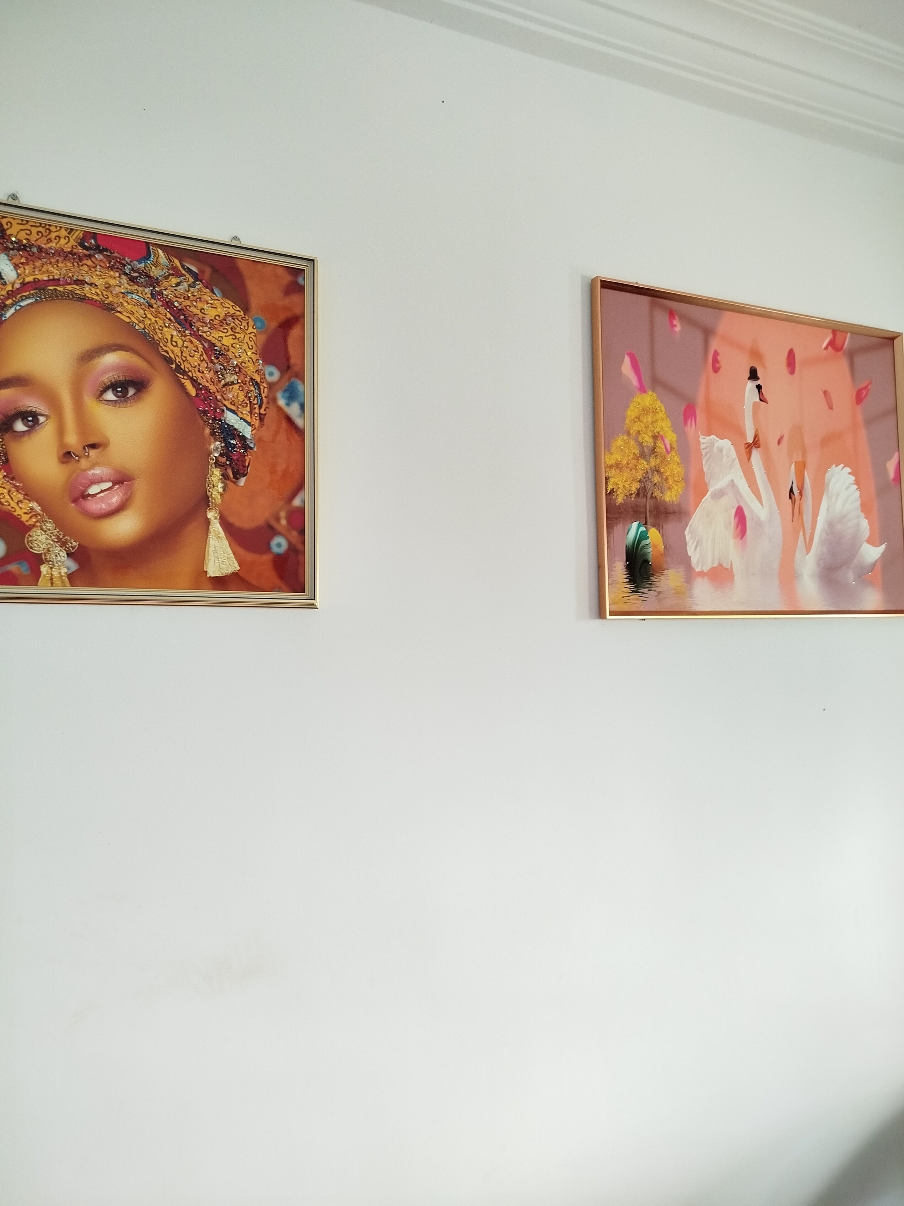 Two framed artworks on a white wall.
