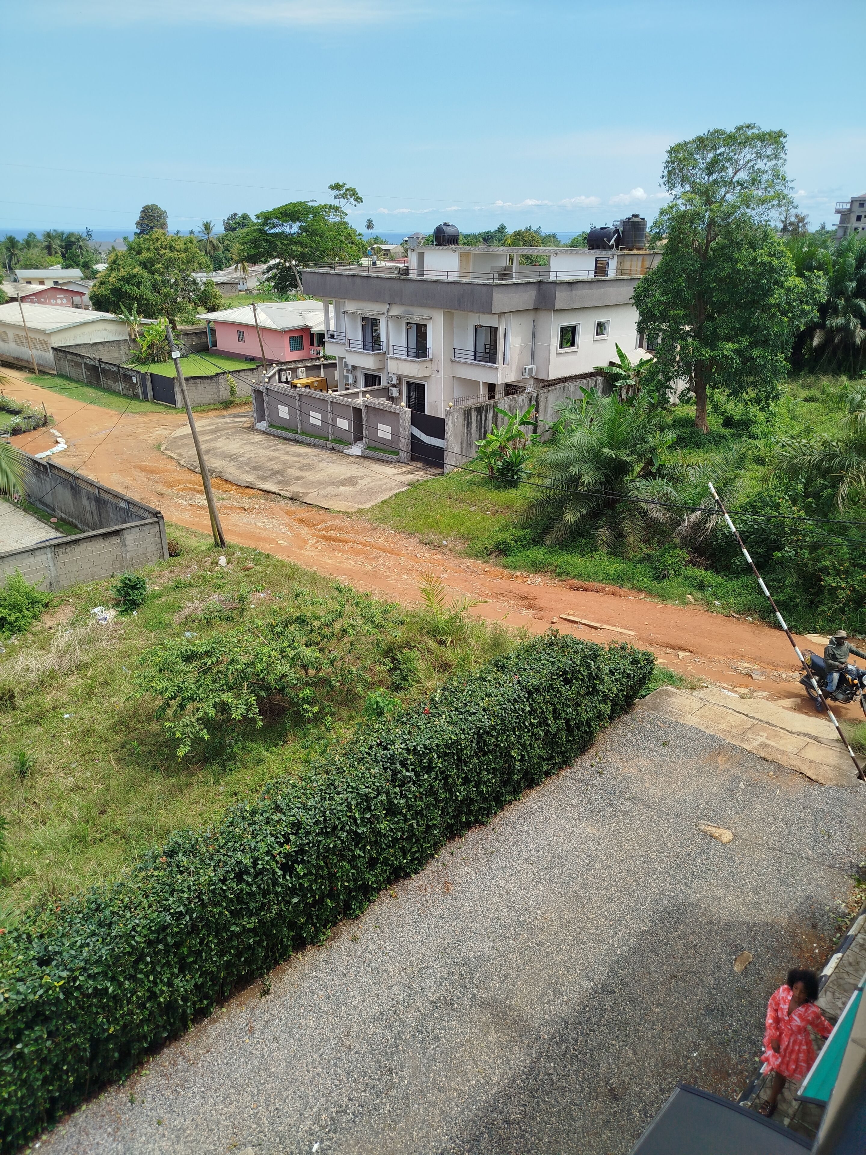 Zona residencial con casas, un camino de tierra y vegetación.