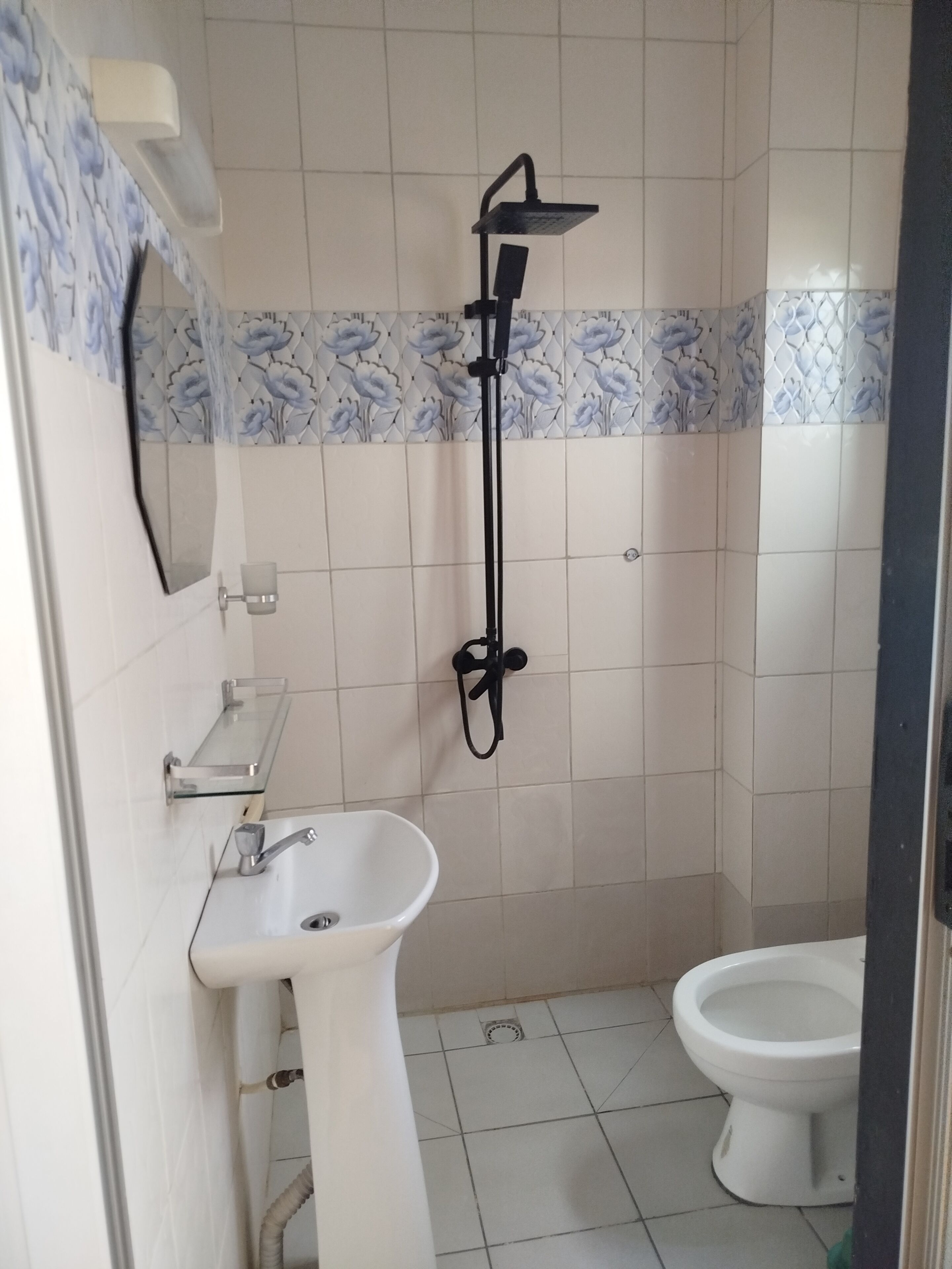 Ein Badezimmer mit Dusche, Waschbecken und Toilette.