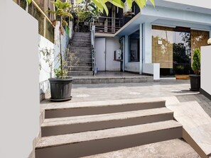 A modern building with a concrete staircase leading to a second-floor landing. - Deluxe Hotel Springs (Alto de Porvorim)