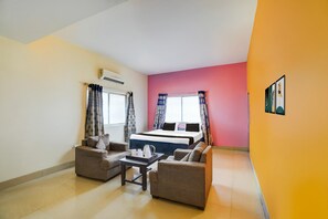 A room with a bed, two sofas, a coffee table, and a window with curtains. - Hotel O Bairiya Bus Terminal Formerly Awadh Palace (Patna)