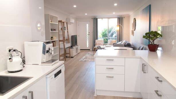 A modern kitchen with white cabinetry, a built-in dishwasher, and a coffee machine. - Family Friendly Coastal Oasis (Scarborough)