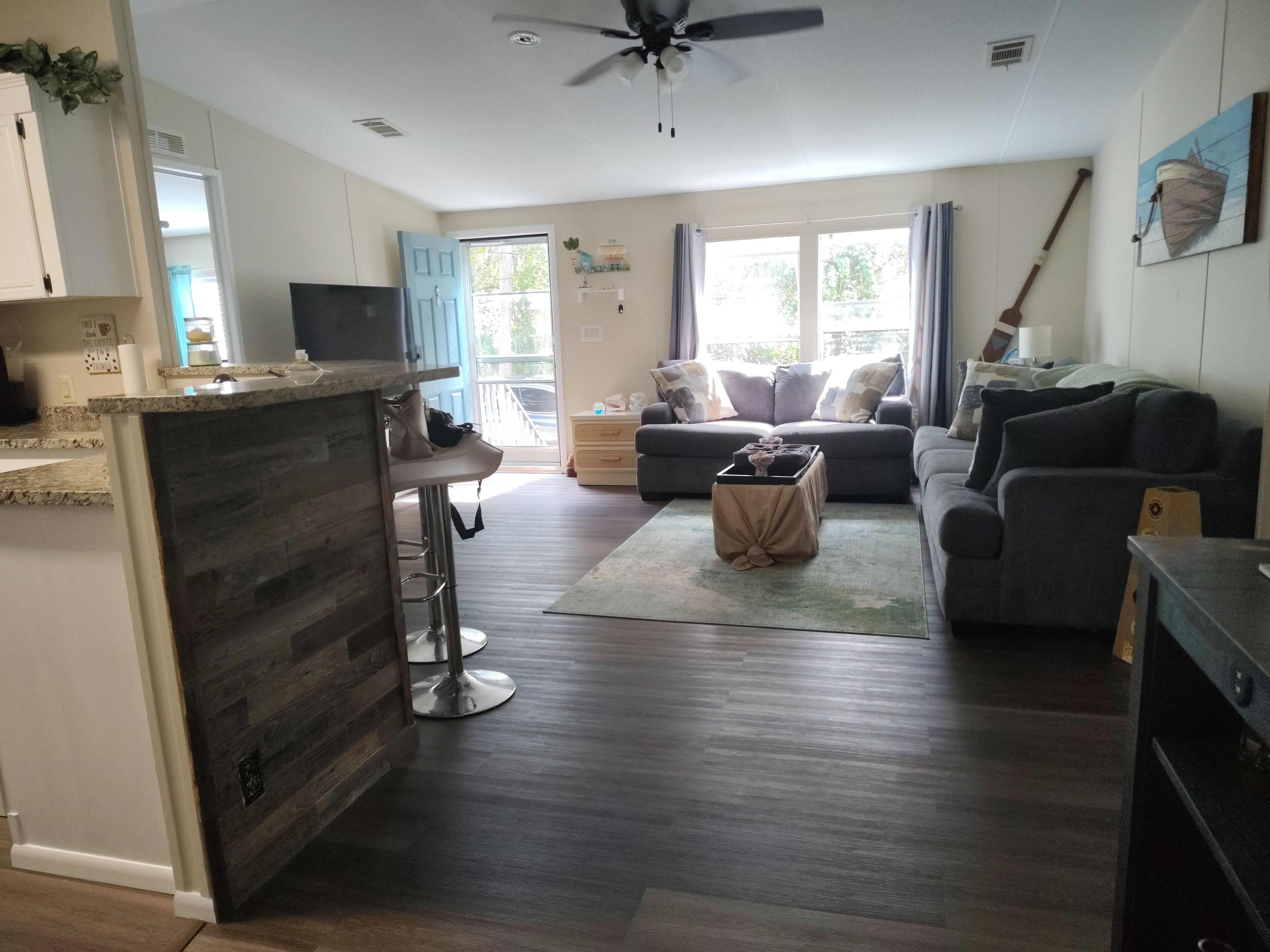 A modern living room with a grey sofa, a coffee table, and a TV.