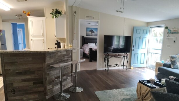 Eine moderne Küche mit Bar, Esstisch und Flachbildfernseher.